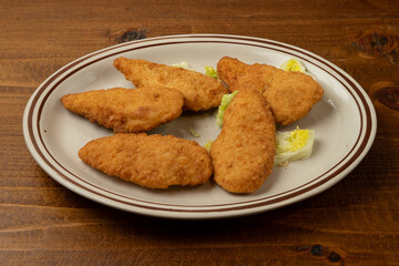 Chicken tenders on a plate.