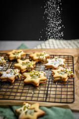 selbst gebackene Plätzchen mit Puderzucker bestreuen, Backen Weihnachten, Weihnachtsbäckerei, 
