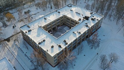 Typical architecture of the Soviet school. What a school building in the USSR looks like under the snow in winter. Typical project of a school in the Soviet Union. Eastern Europe in winter under snow. - obrazy, fototapety, plakaty