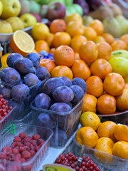 fruits at market, tangerines and plums