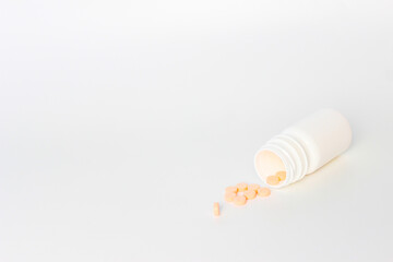 Vitamin D3, Orange Medical Tablets with Bottles on a White Background. Left Copy Space