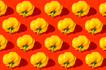 Bright creative pattern made of yellow bell pepper on red background. Minimal style. Healthy food ingredient concept