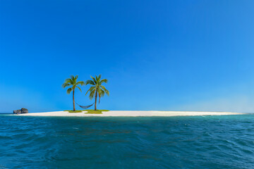 Fototapeta na wymiar Net hammocks, huddled with coconut trees, on the island.