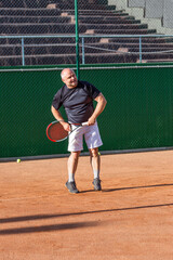 Adult man on the tennis court. Activity, sports and health. Vertical.