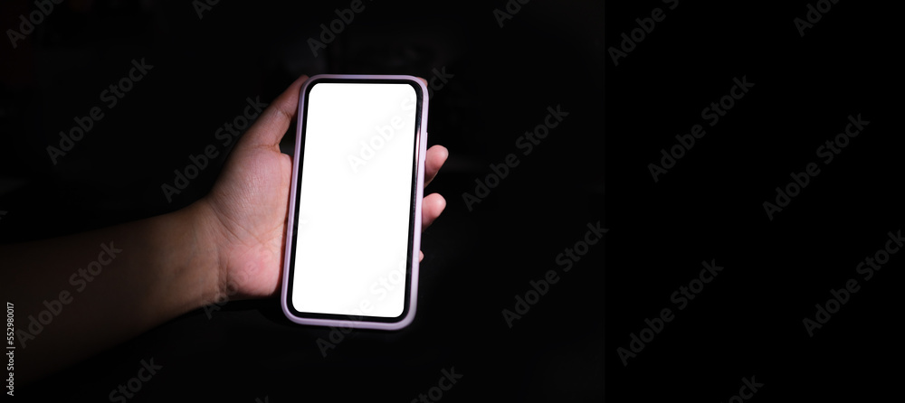 Poster close up view of man hands holding mobile phone. white empty screen for out advertise text..