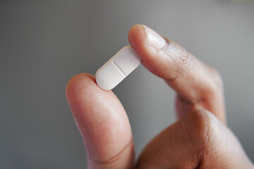 Close up of man hand holding pills with copy space 