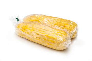 corn cobs in plastic wrap isolated on white background