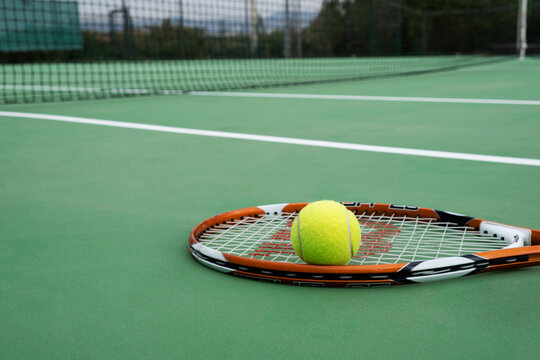Tennis racket and ball, green court