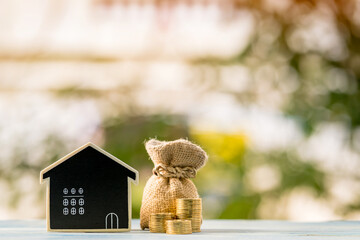 Blackboard is home and money and stack gold coin put on the wooden plate vintage blue in the public...