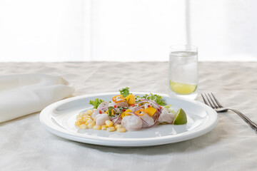 Ceviche, typical fish-based dish of Peruvian cuisine on a table with white tablecloth.