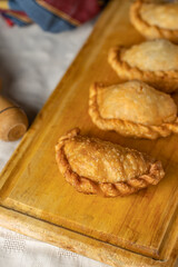 Top view of fried Argentine empanadas on a wooden board.