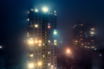 Fototapeta premium Residential building in the fog at night in Kyiv.