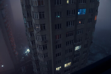 Residential building during a blackout at night in the fog. After the russian missile attacks. Kyiv, Ukraine. - 552989459