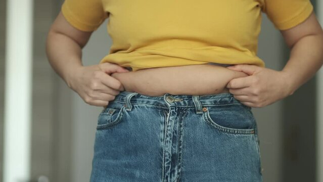 Woman body fat belly. Obese Woman with fat upset about her belly. Fat woman with tight clothing worried about weight diet lifestyle concept.