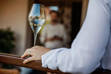 Woman's hand holds a glass of white wine closeup
