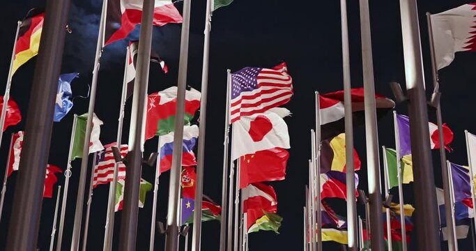 Waving flags at night. The Flag Plaza, displays 119 flags from countries with authorized diplomatic missions, including flags of the European Union, the United Nations, and the GCC