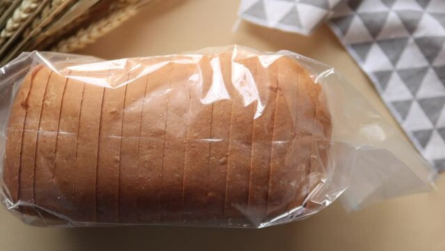 top view of baked bread in a plastic packet on black background 