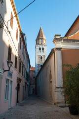Narrow street by the church of Saint Simeon with bell tower in Zadar, Croatia