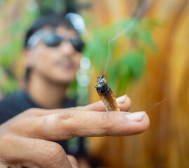 Young man smoking cigarettes with medical marijuana