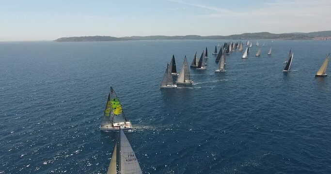 epic aerial view shots of the start of the Rolex Giraglia 2019 regatta, many sailing yachts have started and are making maneuvers dramatic sky