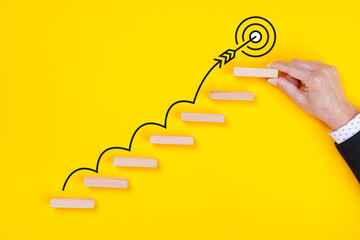 Success ladders and goal achievement concept. Wooden cube held by businesswoman, last step to reach...