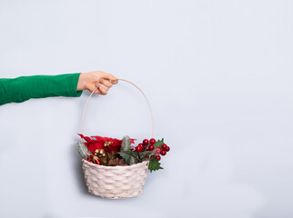 Cute caucasian kid toddler girl hand holds festively decorated basket on white background. Copy space for design or text. Banner. Christmas New Year mockup template.