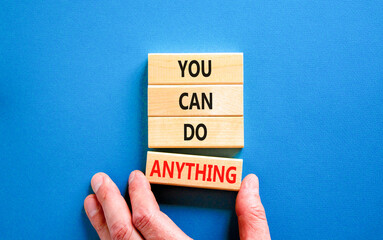 You can do anything symbol. Concept word You can do anything on wooden blocks. Businessman hand. Beautiful blue table blue background. Business and you can do anything concept. Copy space.