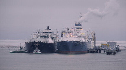 Floating storage and regasification unit and liquified natural gas carrier in the port during the...