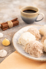 traditional arabic sweets pishmanie and a cup of coffee on brown concrete, side view, selective focus.