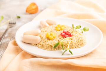 Funny quinoa porridge, and small sausages in form of cat face on brown concrete. side view, selective focus.