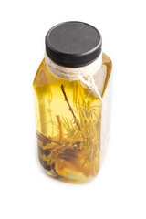 Sunflower oil in a glass jar with various herbs and spices isolated on white. Side view, copy space.
