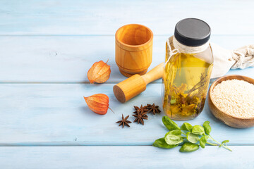 Sunflower oil in a glass jar with various herbs and spices on a brown concrete. Side view, copy...