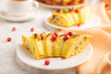 Cheesecake with cup of tea on gray concrete background and orange textile, side view, selective focus.