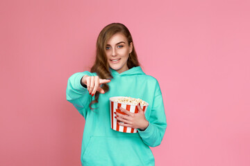 woman in sweatshirt watching movie film, eating popcorn