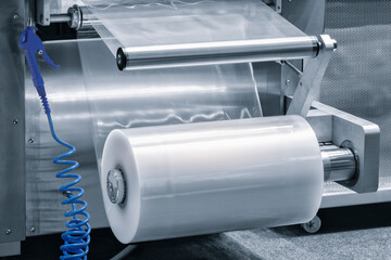 Automatic polyethylene plastic bag production machine with lighting effect. Close-up of the roller...