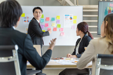 A group of young Asian businessmen Talking and planning work happily and have fun. at the company's office