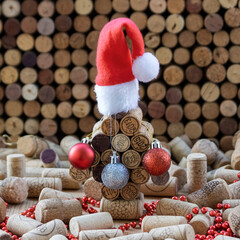 Decorated wine cork Christmas tree among used wine corks on the table