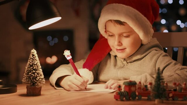 Little boy writing a letter to Santa Claus on Christmas Eve