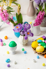 Spring Easter composition with flowers and eggs on light surface