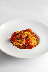 pasta with shrimps and tomatoes on a white background