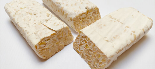 Close up of tempe or tempeh, a typical traditional Indonesian fermented soybeans, using fungi called Rhizopus. Isolated on a white background