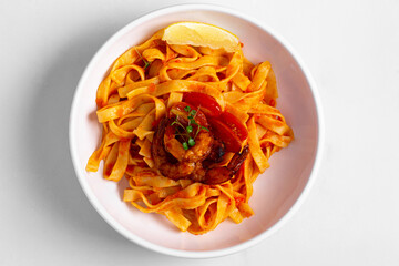 pasta with shrimps and tomatoes on a white background