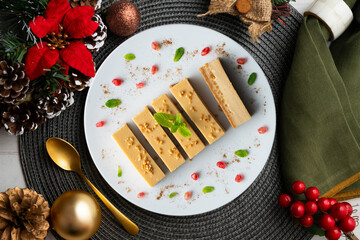 Cheesecake and almond nougat. Typical Christmas dessert served on a table with Christmas decorations.