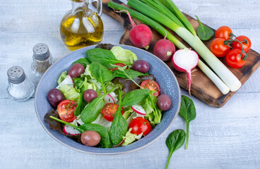Green vegan salad from green leaves mix and vegetables. Top view. Wooden table. 
