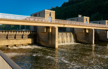 Naklejka premium Concrete water building in a river. Dam to close a water body. Warm evening light in summer. Germany, Esslingen near Stuttgart.