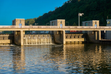 Concrete water building in a river. Dam to close a water body. Warm evening light in summer. Front...