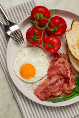 Breakfast, fried egg, bacon and bread, with cherry, on a light background, homemade, no people,