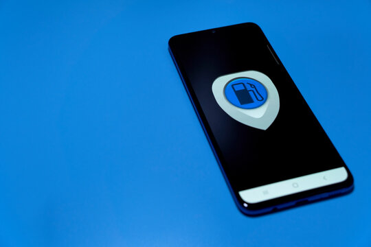 Smartphone with fuel price app (Tank Navigator Mammuth ). Cheap refueling with expensive gas, and energy costs. Isolated on blue.