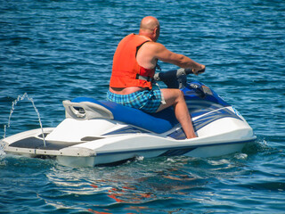 a man is riding on a water scooter. active recreation at sea.