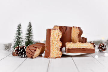 Cut open traditional German layered winter cake called 'Baumkuchen' glazed with chocolate in front...